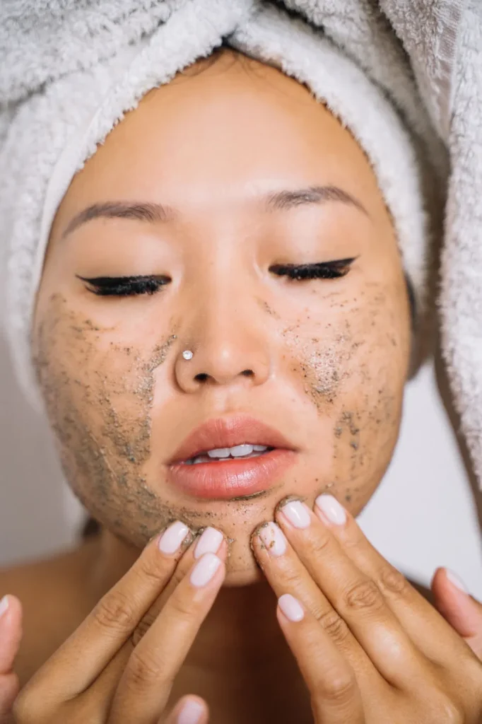 Femme appliquant de exfolifiant sur son visage